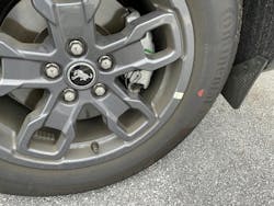 Example of a tire mounted. This tire features only a red dot, with no yellow dot. The wheel features a sticker indicating the wheel low point. The tire is mounted to align the red dot (highest point of radial runout) to this sticker.