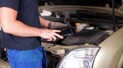 Technician using tablet computer to inspect car